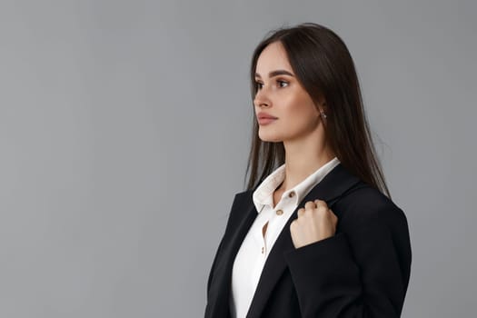 beautiful woman in white shirt and black blazer isolated on grey background. copy space