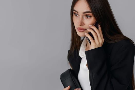 beautiful business woman talking on phone isolated on grey background. copy space