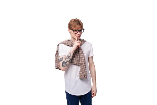 caucasian young man with red hair in a shirt actively tells the news on a white background with copy space. advertising concept.