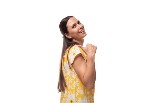 30 year old brunette woman dressed in a summer outfit smiling on a white background with copy space.
