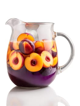 Sangria with slices of peaches plums and nectarines in clear glass pitcher. Drink isolated on transparent background.