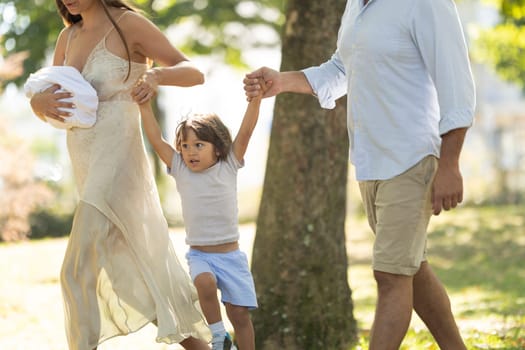 Young family is enjoying a sunny day for a walk in the park