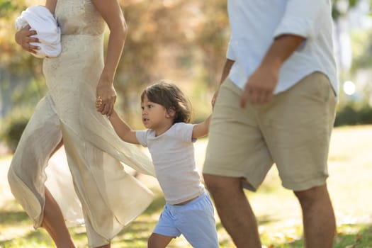 Young family enjoys a leisurely stroll through the park, creating cherished memories together