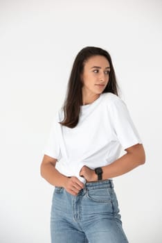 Happy beautiful girl posing in a new hot summer look. Wearing blue jeans and white waistcoat.