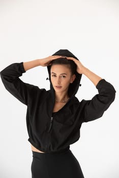 Young athlete girl posing in a black leggings and shirt. indoors.