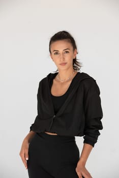 Young athlete girl posing in a black leggings and shirt. indoors.