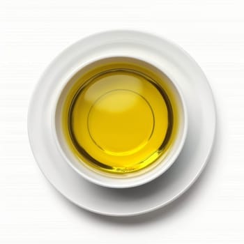 Top view of a bowl of clear yellow liquid, possibly oil or broth, on a white surface
