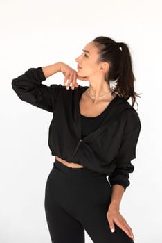 Young athlete girl posing in a black leggings and shirt. indoors.