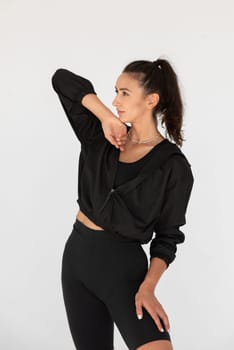Young athlete girl posing in a black leggings and shirt. indoors.