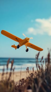 A yellow toy airplane flying near a beach on a sunny day, children's play and imagination concept.