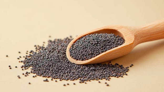 Wooden scoop with black poppy seeds on beige background, close-up. Healthy food and cooking concept.