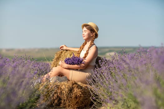 girl sitting field lavender and wearing a straw hat. She is smiling and holding a bouquet of flowers.