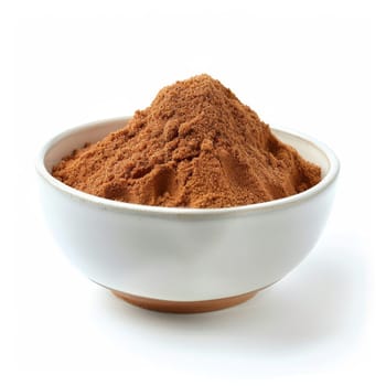 Close-up of ground cinnamon in a white bowl, isolated on a white background