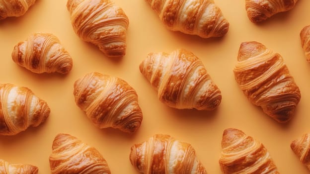 Freshly baked croissants on a yellow background, top view. Bakery and breakfast concept.