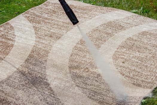washing the carpet with a high pressure washer. Selective focus.