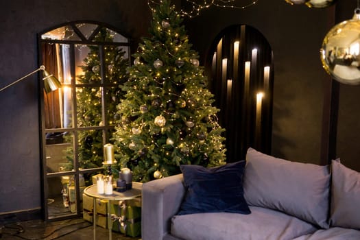 Christmas interior with a beautiful Christmas tree, sofa, light bulbs and dark background