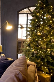 Christmas interior with a beautiful Christmas tree, sofa, light bulbs and dark background