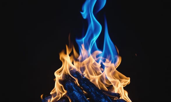 A fire with blue and orange flames burns brightly against a dark background. The flames are tall and thin, creating a dramatic and mesmerizing effect.