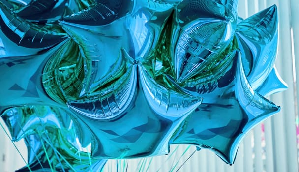 Colorful star-shaped balloons in shades of blue cluster together, adding a festive touch to the atmosphere of a lively gathering filled with joy and excitement.