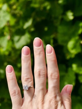 Japanese hygienic manicure on the female hand of the bride with a wedding ring. Clean and safe manicure. Beautiful fingers and nails without gel polish. Vertical