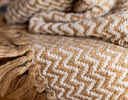 Decorative background of rustic fabric in beige tones .Wallpaper for textile products. Space for copy.High quality horizontal photo.Autumn-colored warm wool blankets.