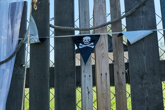 A vignetted background image of the flag of pirates onto wooden boards of a wall
