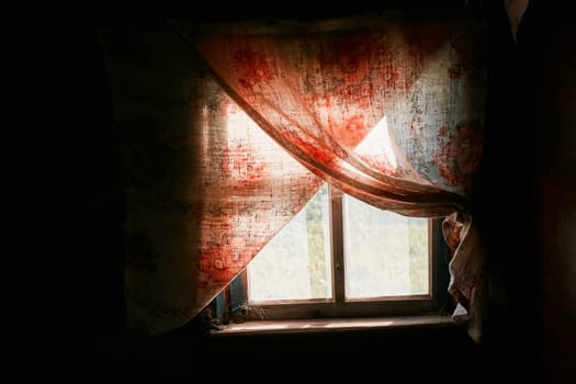 An aged rustic window, curtains and a dark room in the house.