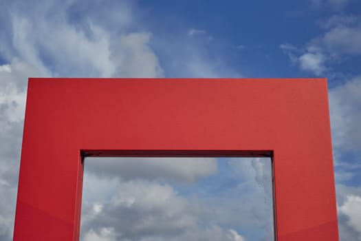 The natural background. A red arched structure against a blue sky background. Modern construction.