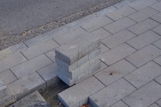 Gray pavement of pedestrian paths. The destroyed paving slabs in the city.