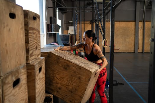 Woman organizing the gym equipment alone in a cross training gym