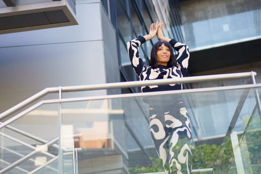 Female caucasian dancer performing and posing from urban stairs in a financial building
