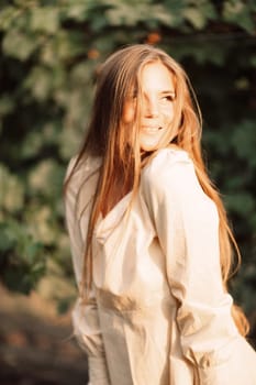 Woman stands in front of vineyard. She is wearing a light dress and posing for a photo. Travel concept to different countries.