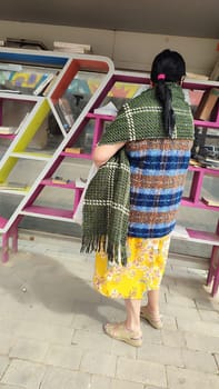 14 March 2024 Beer-Sheva Israel, woman standing by bookshelves, literature library reading learning hobby. High quality photo