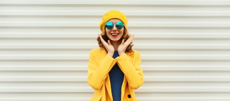 Autumn portrait of beautiful happy laughing surprised woman in yellow french beret hat, stylish girl posing on white background
