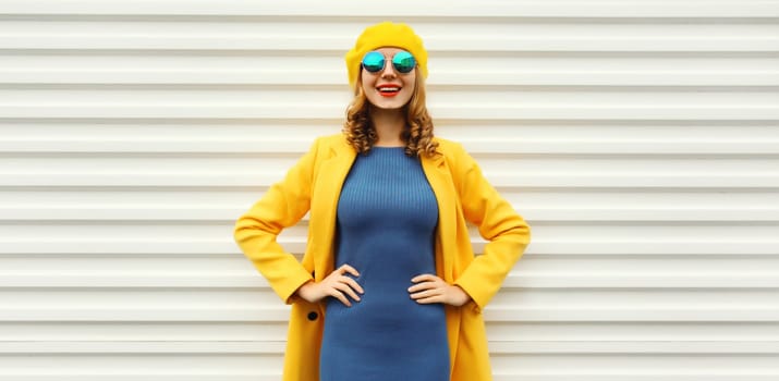 Autumn portrait of beautiful happy smiling woman in yellow french beret hat, stylish trendy girl posing on white background