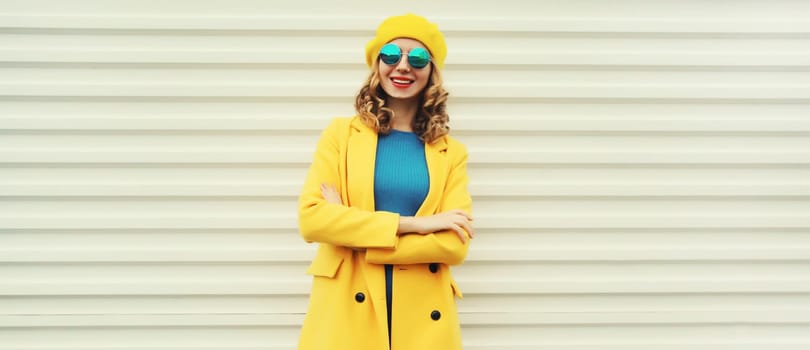 Autumn portrait of beautiful happy smiling woman in yellow french beret hat, stylish trendy girl posing on white background
