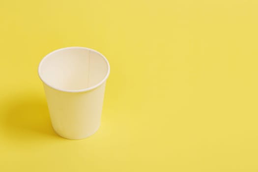 The concept of environmental protection. Copy the space. .Disposable paper cup for coffee and tea on a yellow-orange background. coffee break...