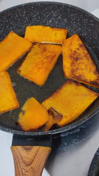 fried pumpkin in a frying pan food cooking lunch dinner, orange vegetables, vegan, vegetarian dish snack diet. High quality photo