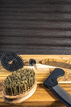 Barber shop flatlay, with different combs and brushes on a wooden table. For a beard.