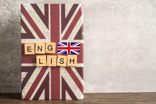 Word English on book with United Kingdom flag, learning English language courses concept.