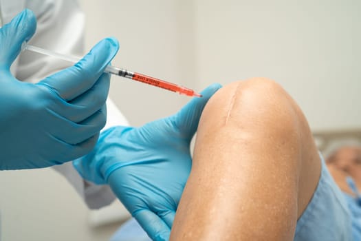 Asian doctor inject Hyaluronic acid platelet rich plasma into the knee of senior woman to walk without pain.