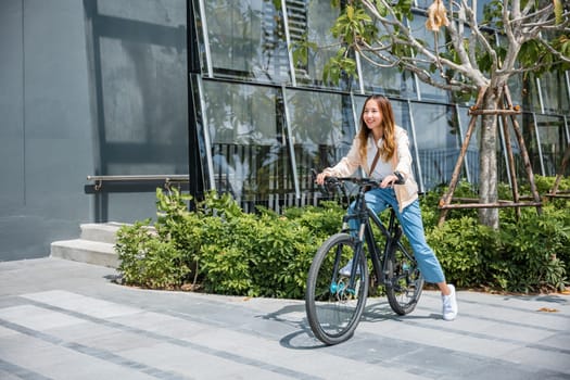 Happy Asian beautiful young woman riding bicycle on street outdoor near building city, Portrait of smiling female lifestyle using bike in summer travel means of transportation, ECO friendly