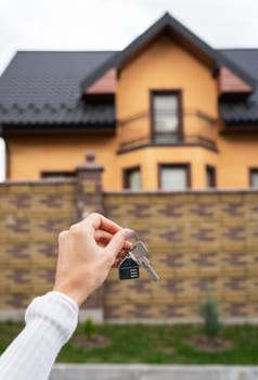 A young adult woman holds a curl with a curl from her new home in her hands. Mortgage, home purchase, long-term lease agreement