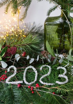 2023 new year green background from live leaves and branches. Seasonal packaging and New Year's paraphernalia. New Year's composition, a ready-made opening