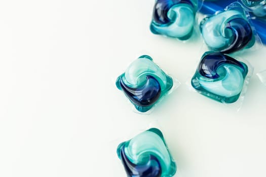 Washing powders in multi-colored capsules on a white background. The concept of washing and cleanliness
