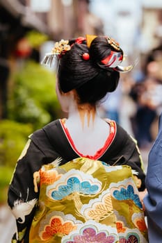 Kyoto, Japan - May 14 2019: Portrait of a young Maiko Geisha who is being led to houses of clientele by her guide in Gion district of Kyoto, Japan
