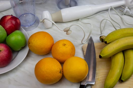 Fresh fruits on the table for healthy drink in blender in kitchen at home. Making tonic healthy drink from fruits for human body benefit
