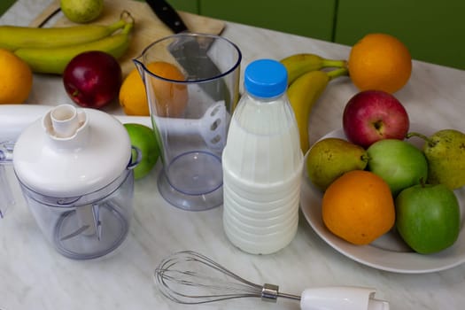 Table with blender and ingredients for making sports drink. Milk and fruits for making smoothies and tasty cool drink. Healthy and tasty food for sports people