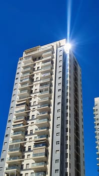 construction of a high-rise gray building, windows office building, city object, blue sky . High quality photo
