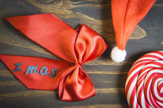 Flatlay of some Red typical Christmas decorations, on a dark wooden background. Christmas background.
